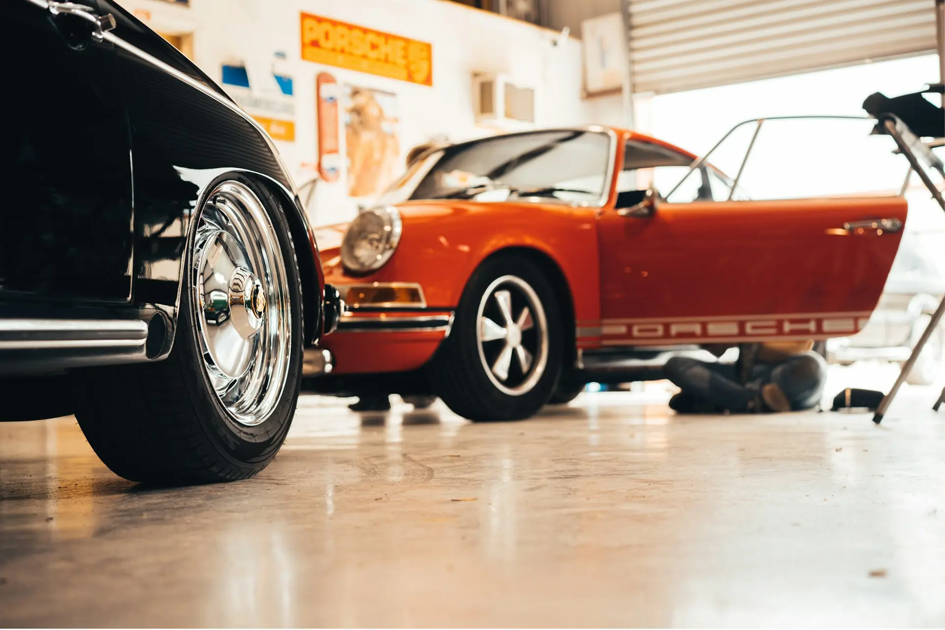 A collision repair shop floor with a car mid-refinish