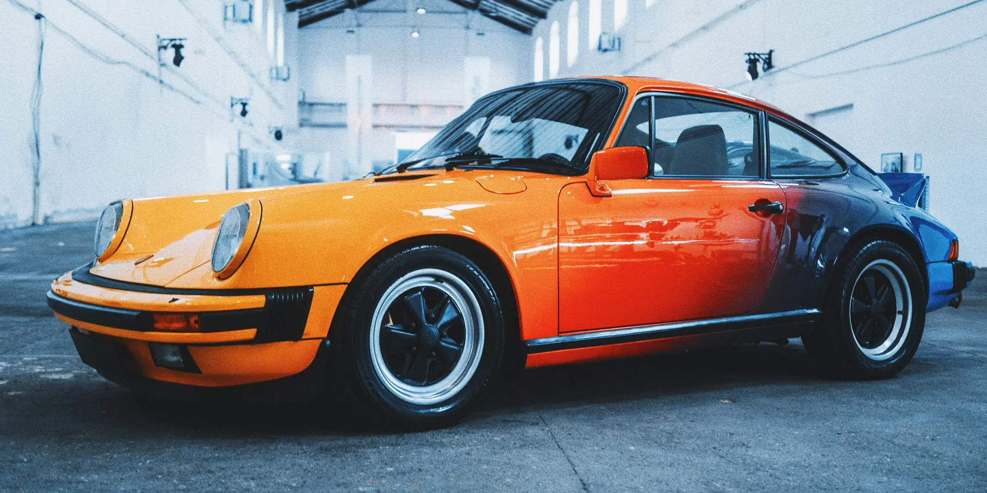 A freshly refinished car with a two-tone paint job in a body shop